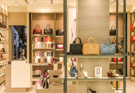 Negozio di borse moderno, con mura in legno, prodotti in mostra sono scarpe, borse, portafogli.